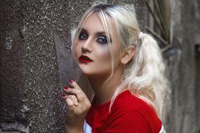 fatal blonde posing near the wall