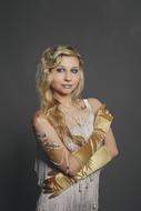 photo of a blonde in a white dress and gold gloves