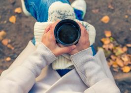 girl in white clothes holding a cup of coffee