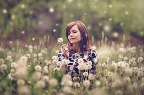 Woman with white dandelion on Meadow