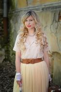 beautiful girl in vintage pale dress at grunge wall