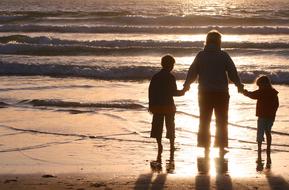 family holding hands on the evening beach