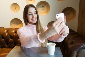 Young Girl taking selfie in cafe