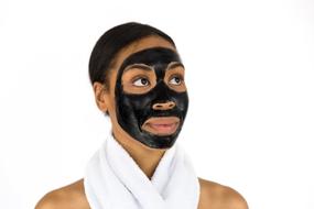 photo portrait of a girl with a black charcoal mask on her face