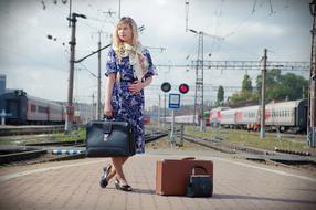 picture of the back in The Ussr, attractive girl with vintage luggage on railway Station