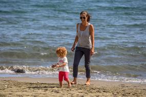 mother with daughter by the sea on a sunny day