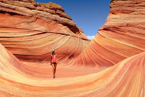 Adventure, cool girl walking in gorgeous red sandstone Canyon