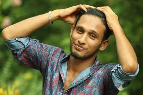 attractive young guy on blurred background with the plants