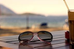 sunglasses lie on the table on the beach