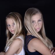 portrait of two sisters on a black background