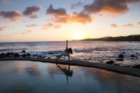 woman doing Yoga Exercise on beach at surf line