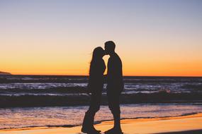 Man Woman kisses sea sunset