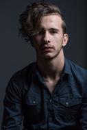 Portrait of the boy, in blue shirt, at black background