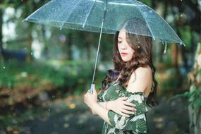 girl under a transparent umbrella among nature