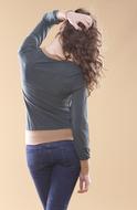 Back view of the posing woman, touching her curly hat