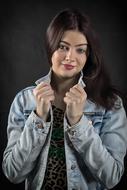 Portrait of the beautiful, posing woman, in the denim jacket, with the make-up
