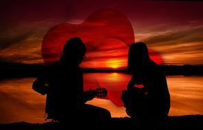 silhouettes of romantic couple at sunset