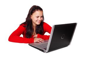 girl in a red sweater works at the computer