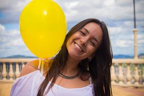 photo of a joyful girl with a yellow balloon