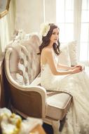 girl in Wedding Dress sits on luxury sofa