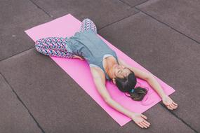 Girl doing yoga on the pink mat
