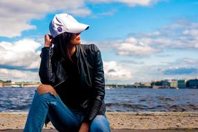 girl in a cap on the embankment on a sunny day