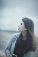 long hair Asian woman looking aside