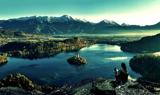 woman with dog looking at lake