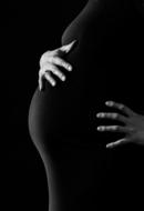 Black and white photo a pregnant woman, touching her belly