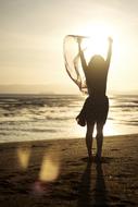 Woman with veil in hand on Beach