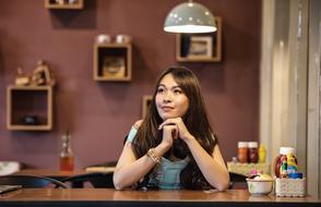 attractive young woman sits at table