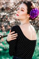 model with purple flower in hair