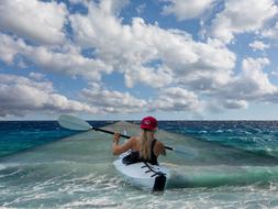 young girl in kayak floating away in sea