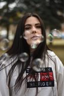 young Girl behind soap bubbles