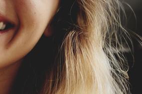 half face of a smiling girl close-up on a blurred background