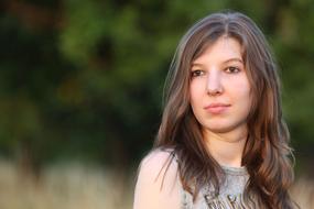 Portrait of the posing woman on green blurred background