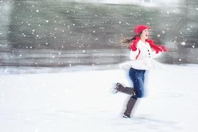 joyful girl running under the snow