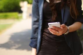 woman holding white smartphone