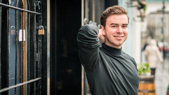 young man posing on city street