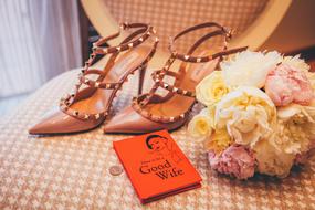 Shoes, book and flowers of the bride on the chair