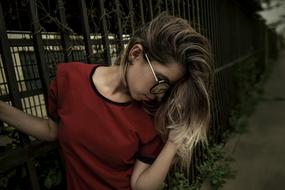 young Woman in big glasses Posing at metal grid