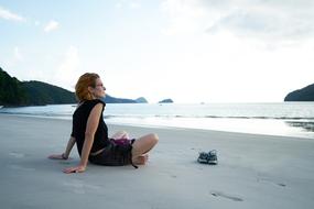 Woman sits Relaxed on Beach