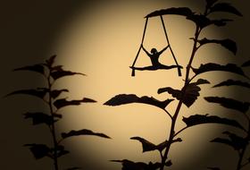 woman doing exercise on tightrope beneath leaf, shadow play