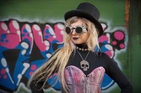 girl in a suit and glasses on the background of a wall with graffiti