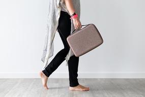 Walking, woman with the suitcase, at white wall on background