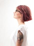 studio portrait of a woman with pink hair and tattoo