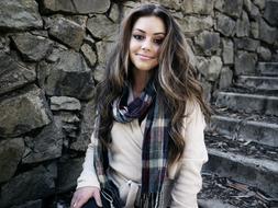 photo of a beautiful girl with a plaid scarf on a background of stone steps
