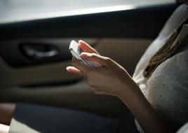 girl with a smartphone is sitting in the car