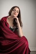 attractive girl sits in Red cape