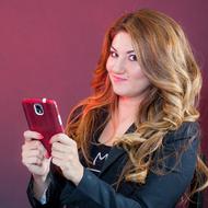 Portrait of a smiling woman with red smartphone, in red light